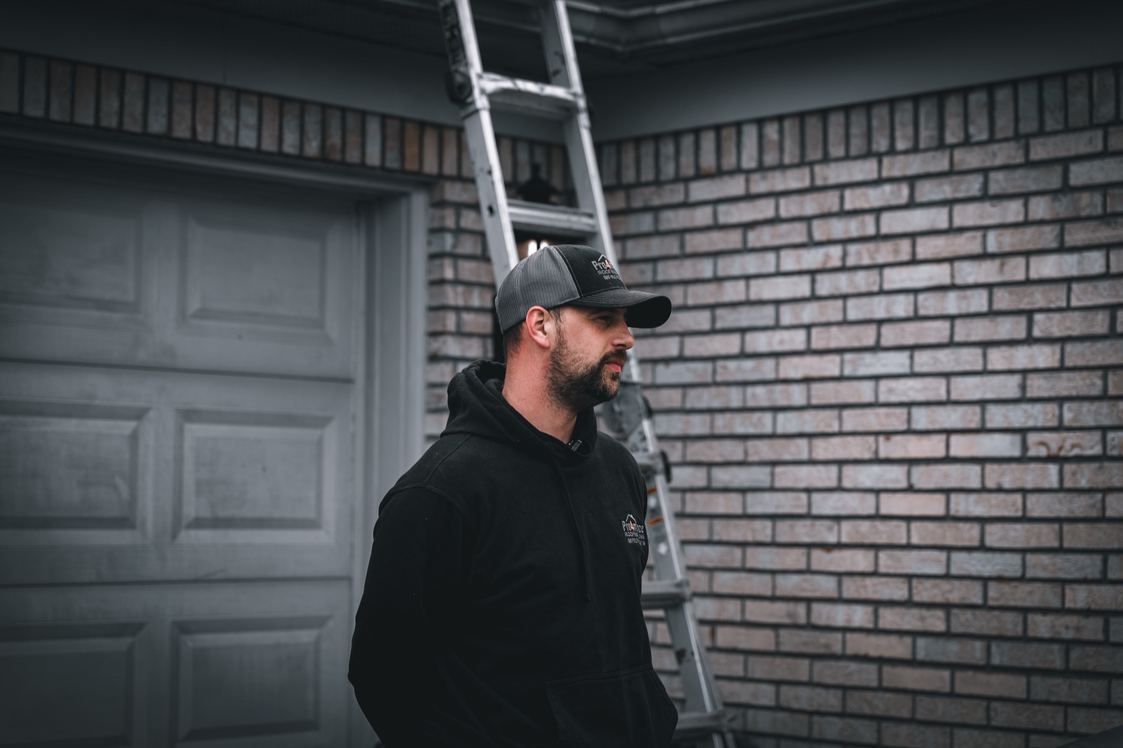 Roofer inspecting shingles on a residential roof