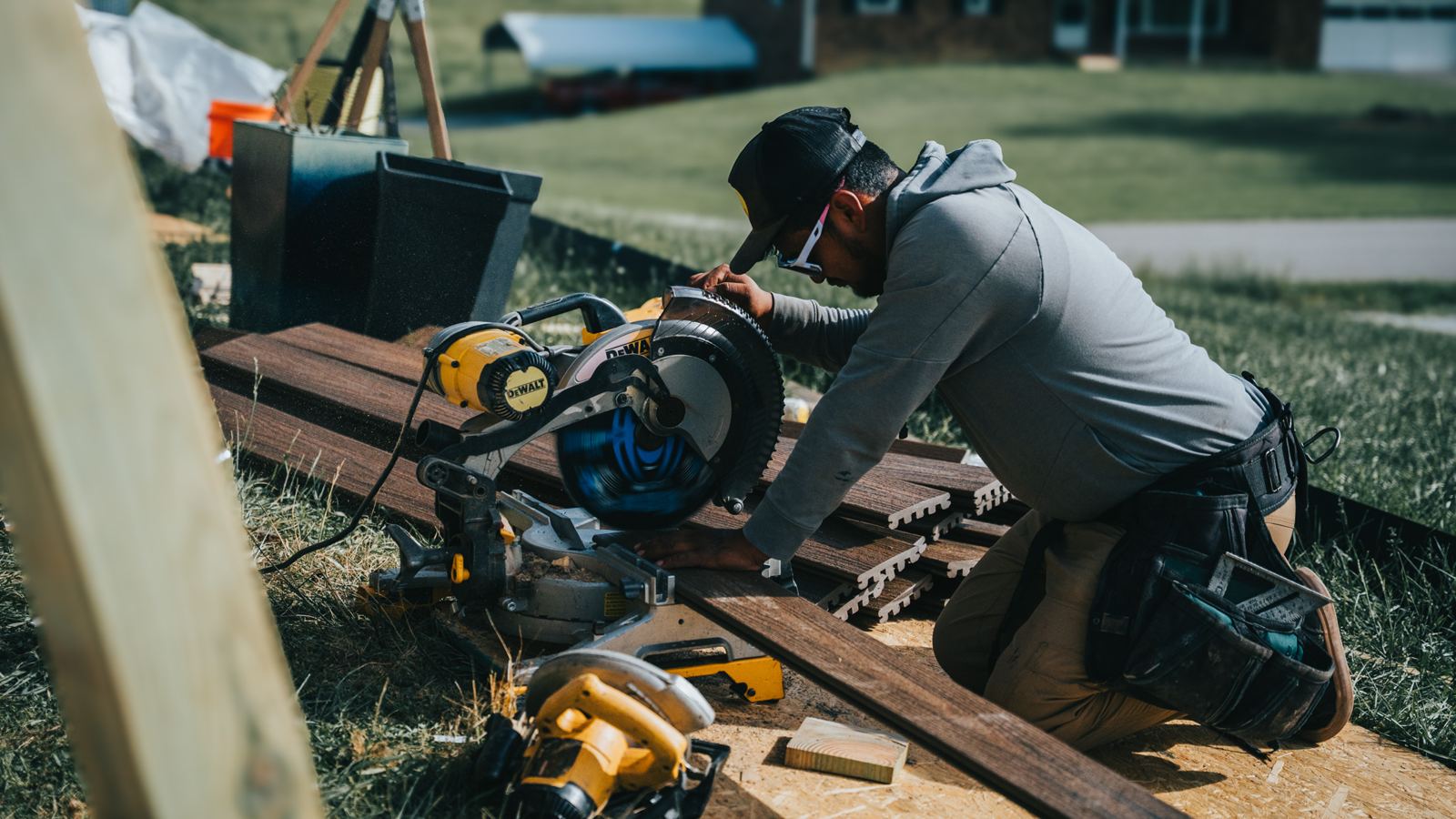 Pro4mance carpenter cutting deck boards with a miter saw