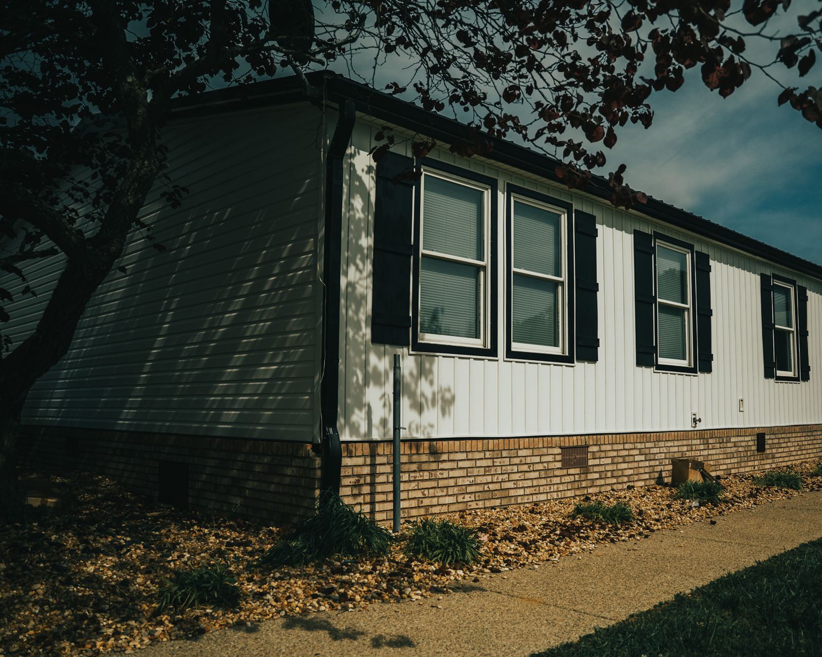 White vertical siding with black shutters finished by Pro4mance on a home near London, KY
